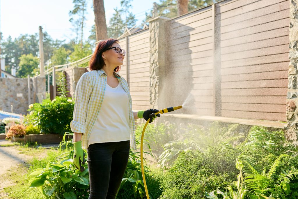 femme arrosant son jardin
